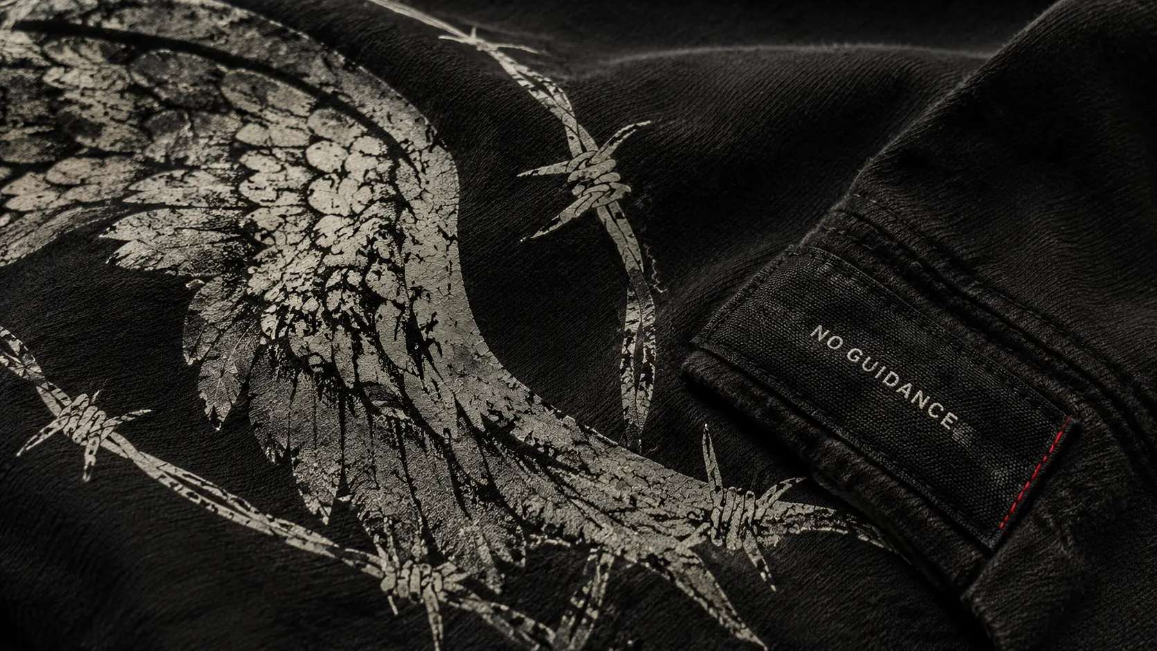 Close-up of a No Guidance wing graphic and woven label